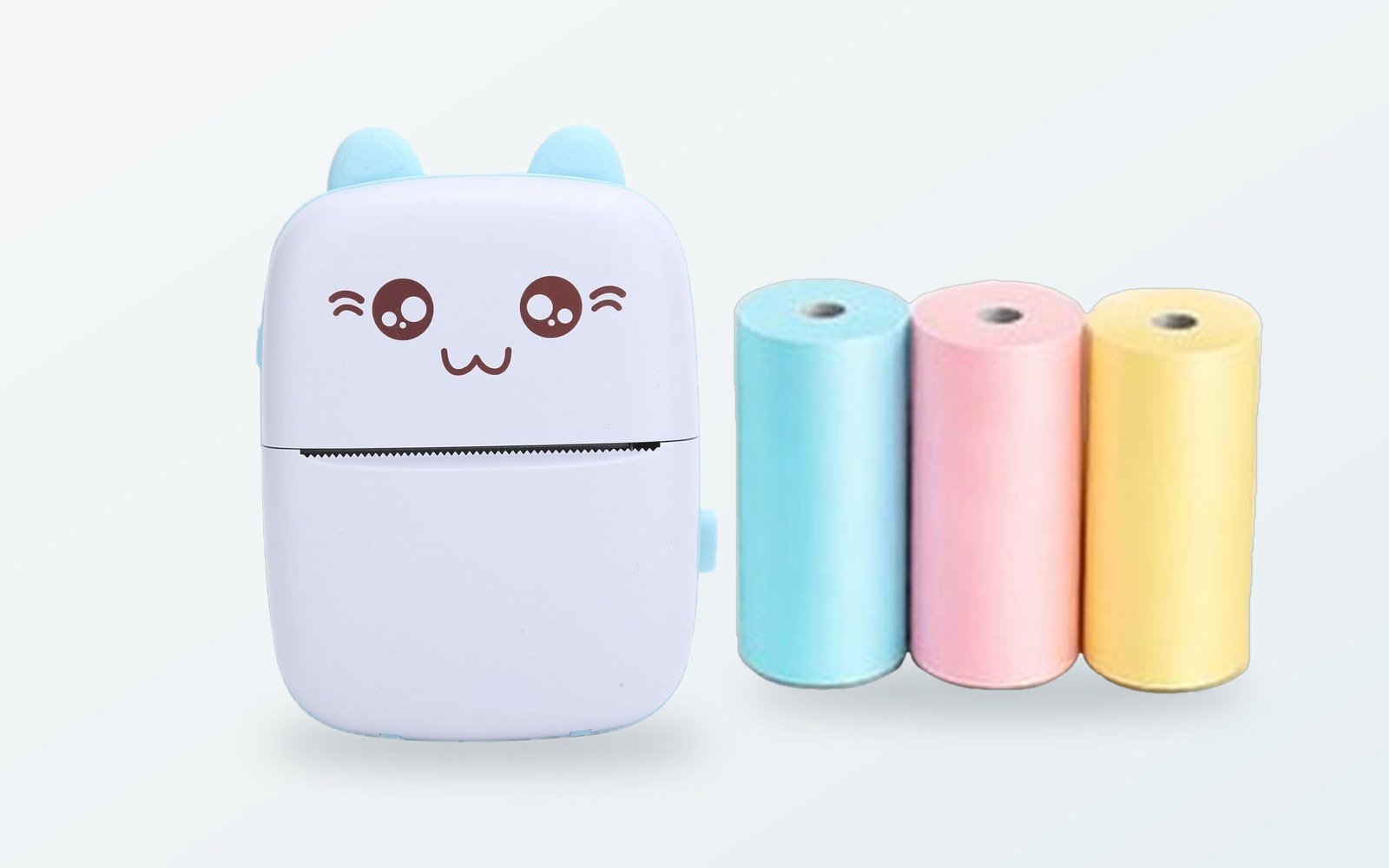 Kedi yüzlü mavi kulaklı mini termal yazıcının yanında mavi, pembe ve sarı termal kağıt ruloları